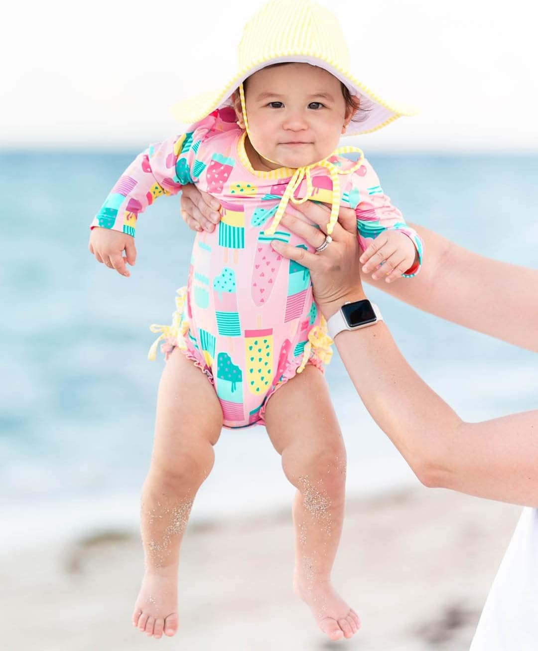 RuffleButts Baby Girls UPF 50+ Sun Protection Novelty Print Long Sleeve One Piece Rash Guard Swimsuit with Zipper