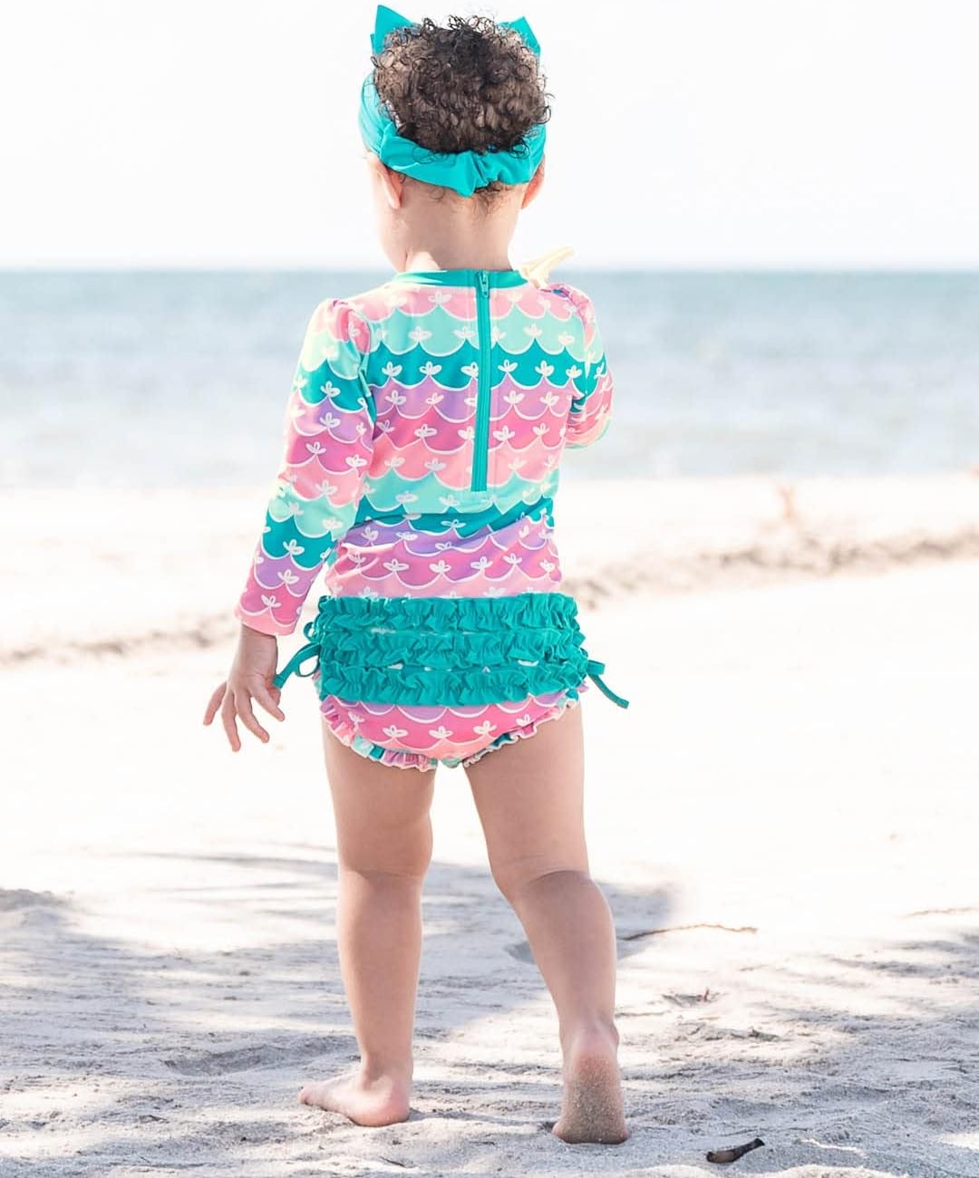 RuffleButts Baby Girls UPF 50+ Sun Protection Novelty Print Long Sleeve One Piece Rash Guard Swimsuit with Zipper