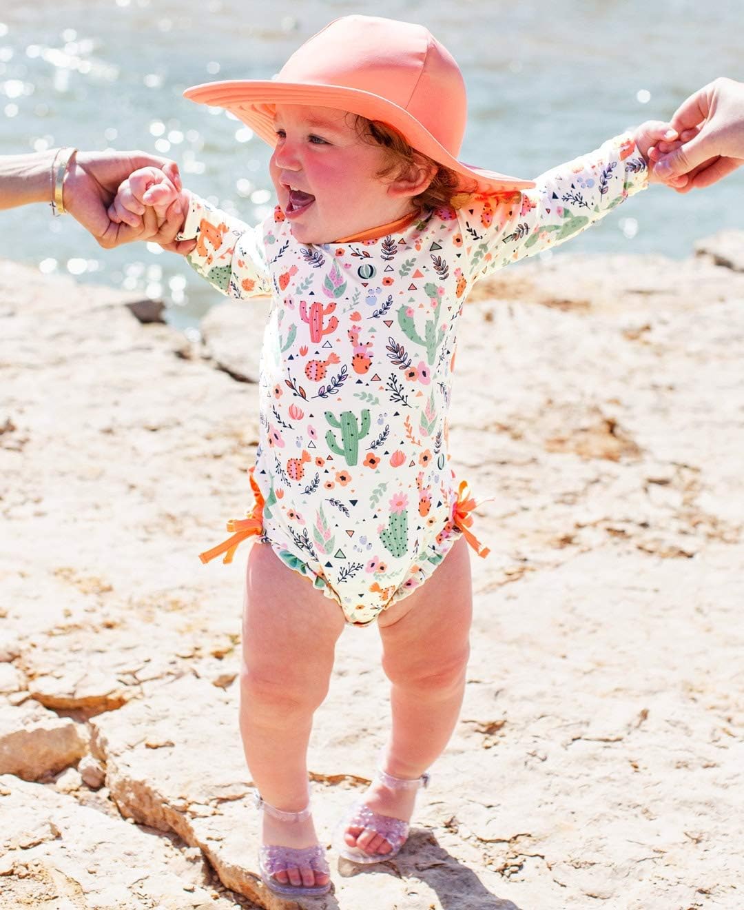 RuffleButts Baby Girls UPF 50+ Sun Protection Novelty Print Long Sleeve One Piece Rash Guard Swimsuit with Zipper