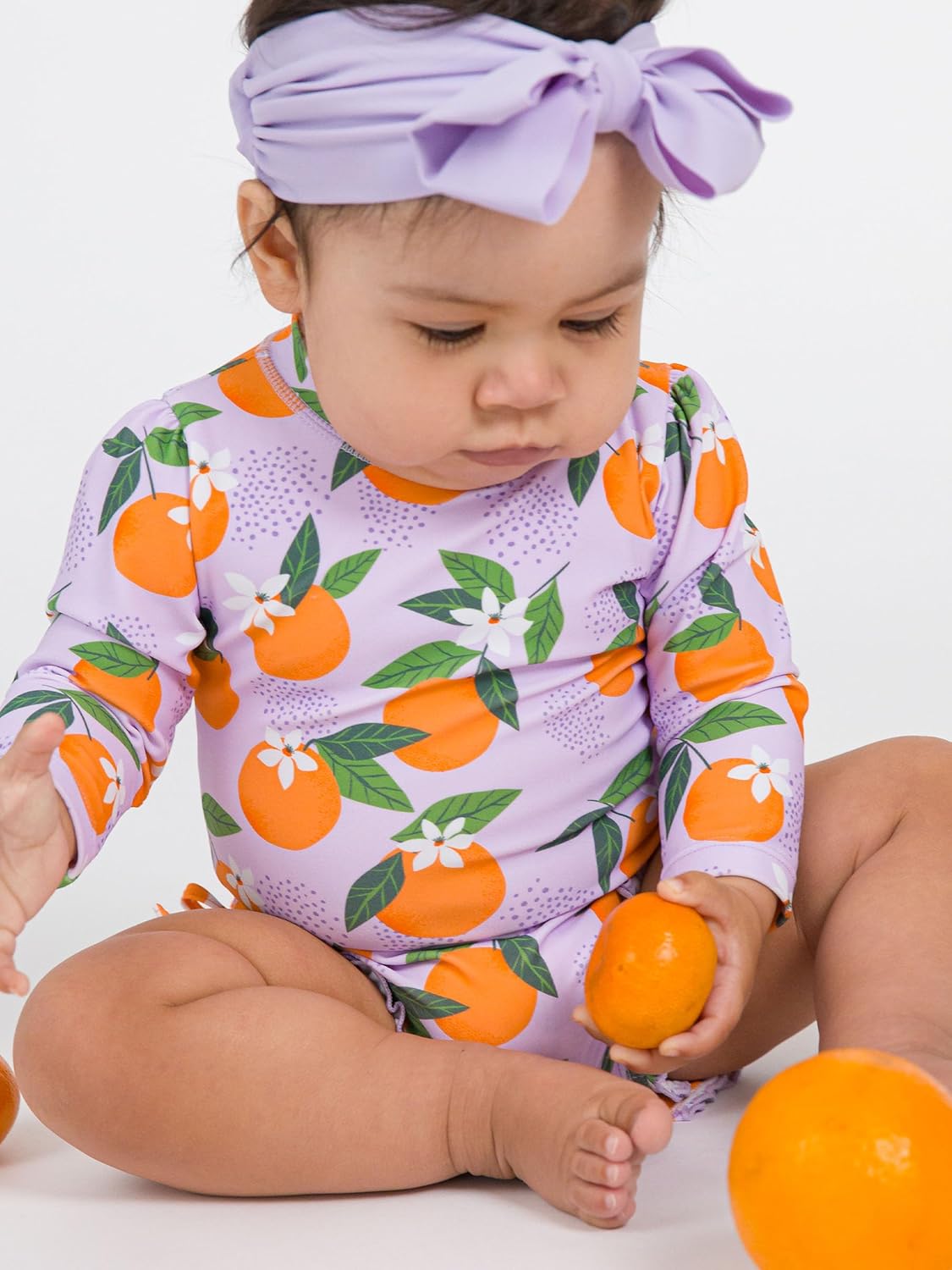 RuffleButts Baby Girls UPF 50+ Sun Protection Novelty Print Long Sleeve One Piece Rash Guard Swimsuit with Zipper