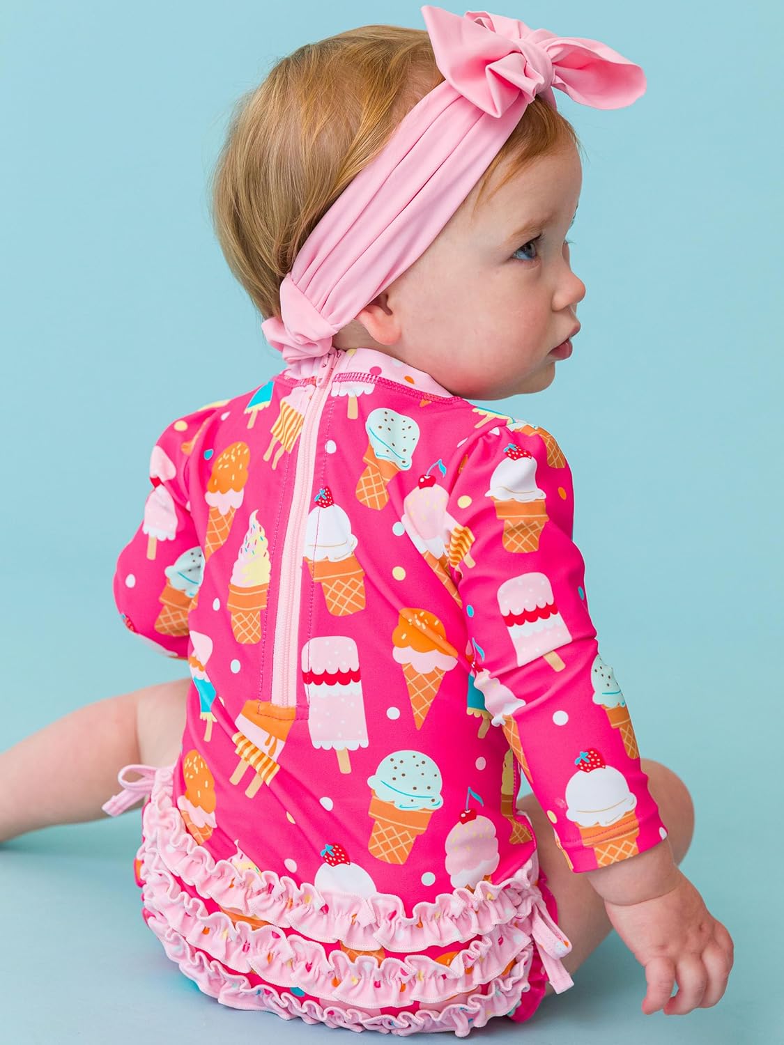 RuffleButts Baby Girls UPF 50+ Sun Protection Novelty Print Long Sleeve One Piece Rash Guard Swimsuit with Zipper