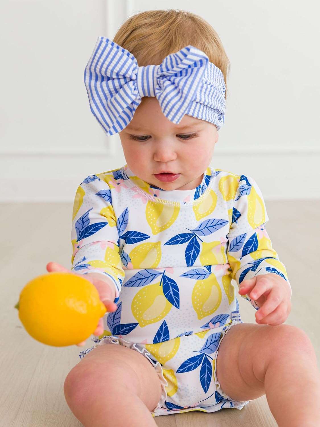 RuffleButts Baby Girls UPF 50+ Sun Protection Novelty Print Long Sleeve One Piece Rash Guard Swimsuit with Zipper