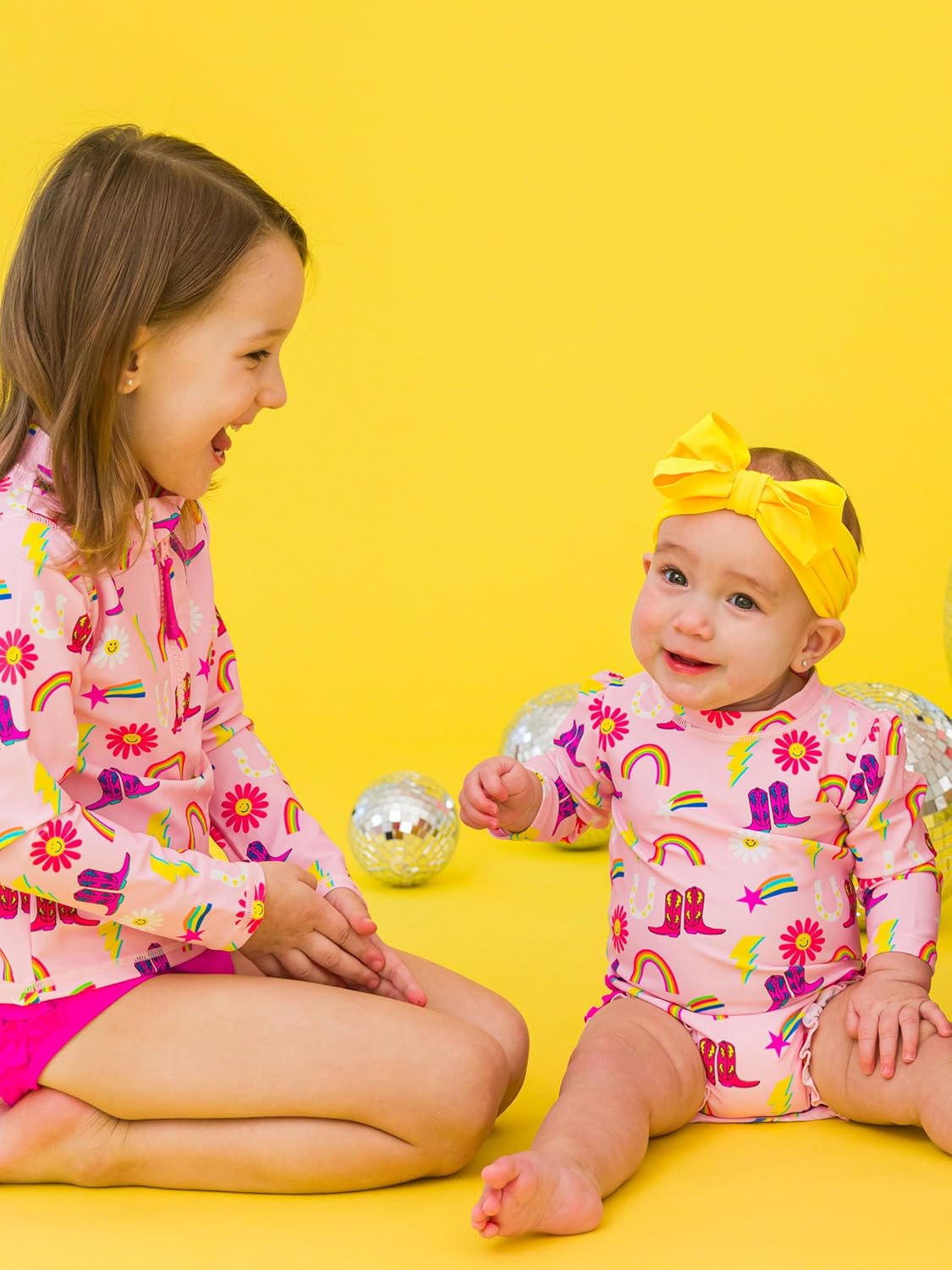 RuffleButts Baby Girls UPF 50+ Sun Protection Novelty Print Long Sleeve One Piece Rash Guard Swimsuit with Zipper